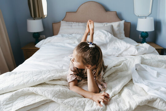 A young girl is lying on the bed.