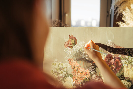 anonymous artist paints flowers on canvas