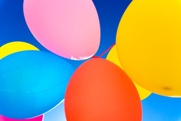Colorful balloons inflated against the sun, festive and joyful colorful background.