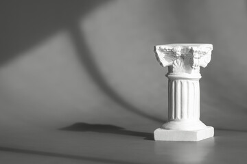 Roman marble column backdrop with art deco decor, display, mockup. Gray background for product presentation with shadows and light from windows. Window natural shadow overlay effect on grey surface.