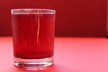 red drink of milky preparation of raspberry blueberries or kulbnik mors juice compote on a red background with a place for text and copyspace © Кристина Шоба