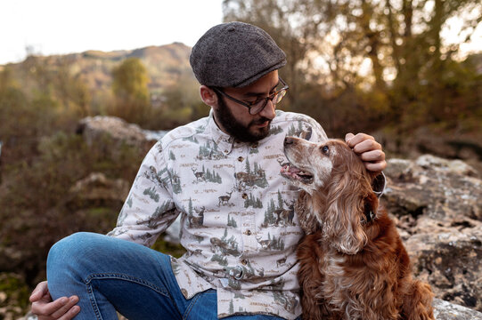 Bearded owner hugging cute dog