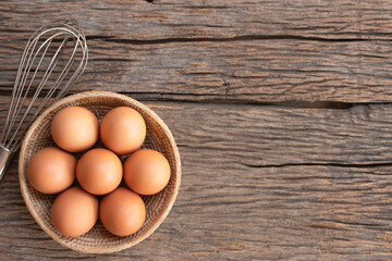 Chicken eggs, brown eggs in carton box on wooden rustic table. Top view eggs bowl. Copy space.