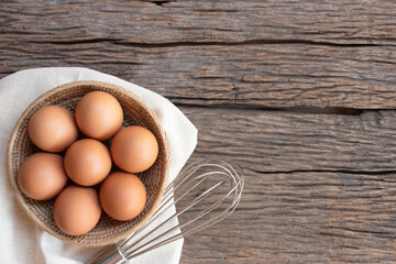 Chicken eggs, brown eggs in carton box on wooden rustic table. Top view eggs bowl. Copy space.