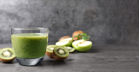 Delicious kiwi smoothie and fresh fruits on grey table. Space for text