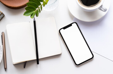 White home office tabletop with smartphone mock-up, coffee cup and notepad