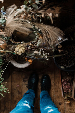 feet/ shoes with dried flowers on the floor