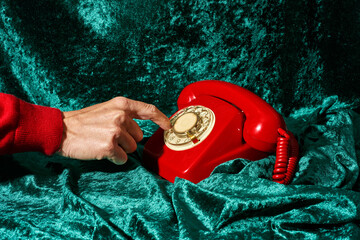 man dialing on a red telephone