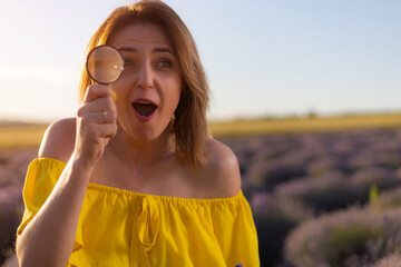 Beautiful and pretty young woman in yellow dress relaxes and enjoys walk in the lavender field at...