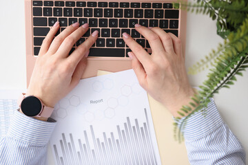 Female hands typing on laptop keyboard closeup