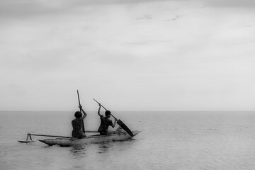 people paddle home in their canoe across the salomon sea in Papua New Guinea
