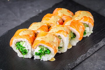 appetizing sushi roll philadelphia with salmon cucumber and chuka on a black stone plate