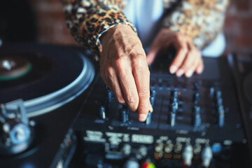 View of Dj mixer and vinyl plate with headphones on a table with DJ playing and mixes the track in...