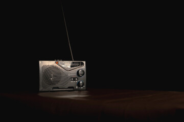 Transistor radio on the table in black backdrop.