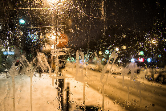 Snowy and frozen reflections of Paris at nigh seen through a phone cabine