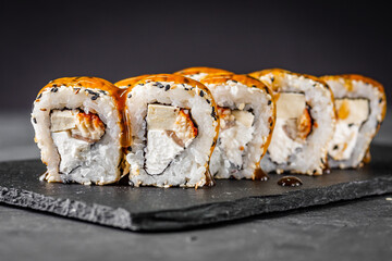 appetizing sushi roll california with eel tofu sesame and unagi cheese on a black stone plate