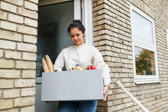 Smiling Woman Holding A Grocery Delivery Box