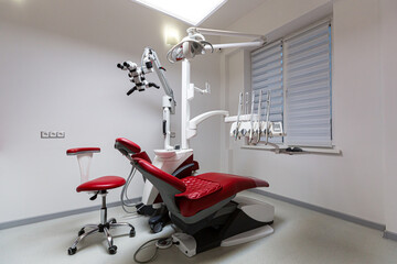 interior of the dental clinic, dental chair in red, with medical equipment