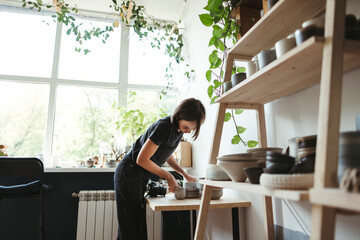 Female artisan makes ceramic products.