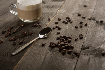 Cappuccino con schiuma con chicchi di caffe in un tavolo di legno 