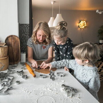 Mother with children baking Christmas cookies