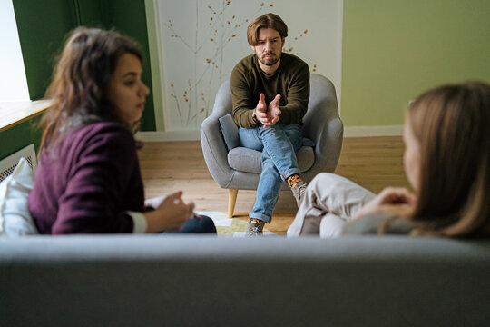 Male therapist speaking with female clients