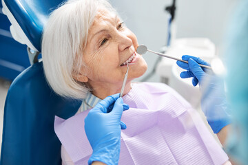 Smiling pensioner showing teeth for dental inspection