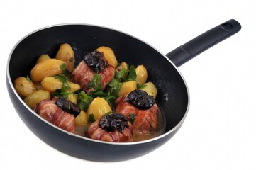 Paupiettes de lapin aux pruneaux avec des pommes de terre cuisinées dans une poêle en gros plan sur fond blanc