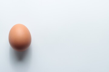 chicken egg at a side of  white empty space background. 