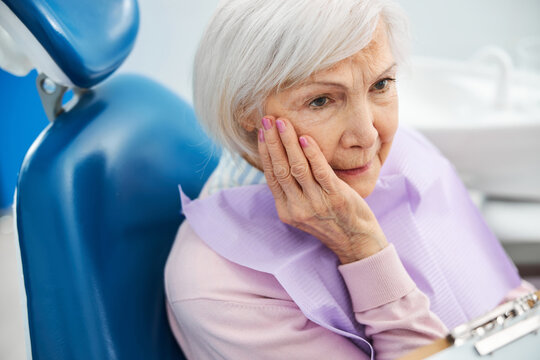 Concerned retiree with toothache staring at dentist