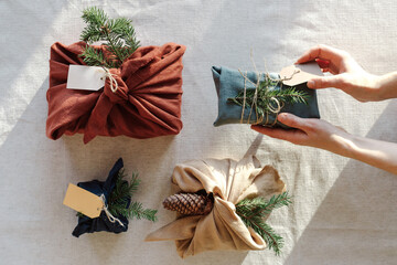 Woman holding Christmas gifts in linen cloth