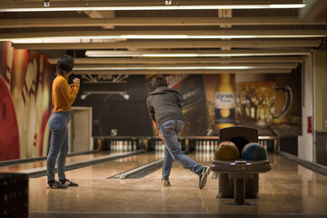 Couple in bowling alley. Man throwing a bowling ball.