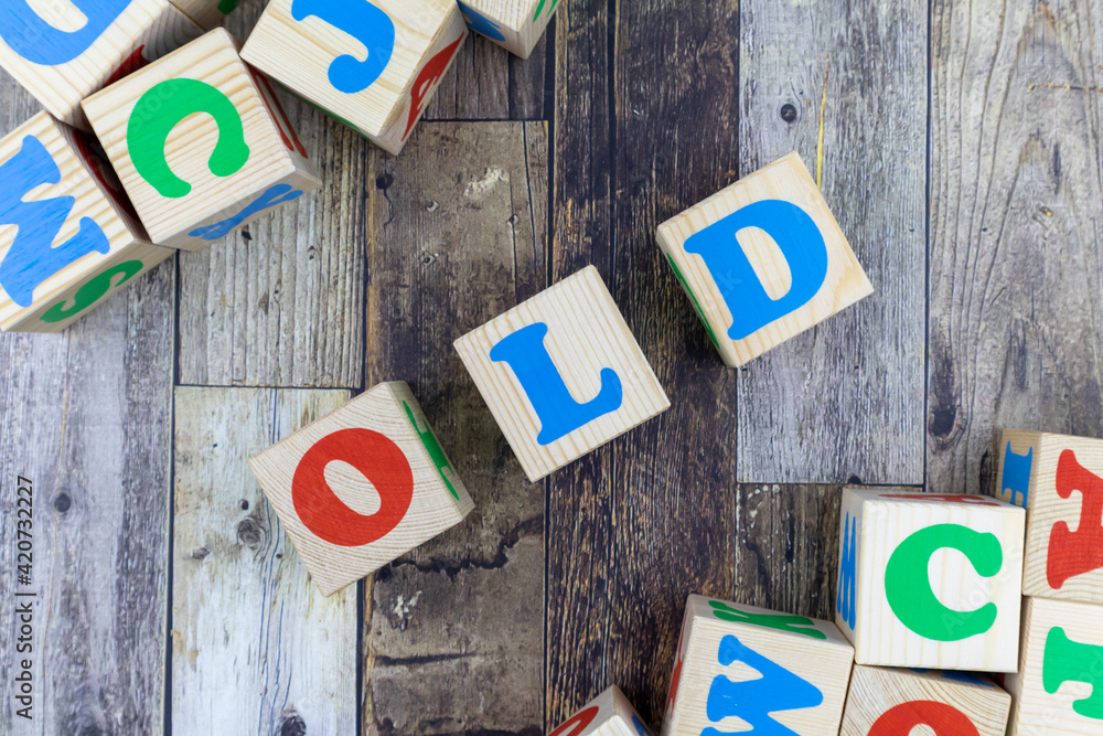 Poster colourful alphabet letters on wooden cubes with word - old - in a diagonal line with additional bloc