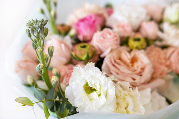 Beautiful wedding bouquet on bright background. Bouquet consists of pink roses, ranunculus, eucalyptus