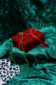 red glittering gift box on a green velvety fabric