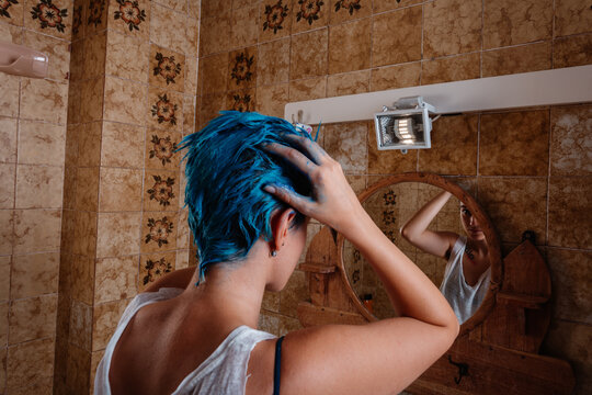 Androgyne Woman Dyeing Her Hair Blue With The Hands At Home