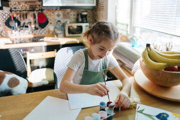 A little girl is engaged in drawing at home