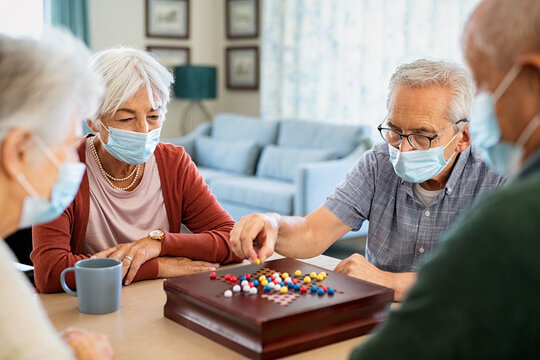Senior friends playing chinese checkers at nursing home