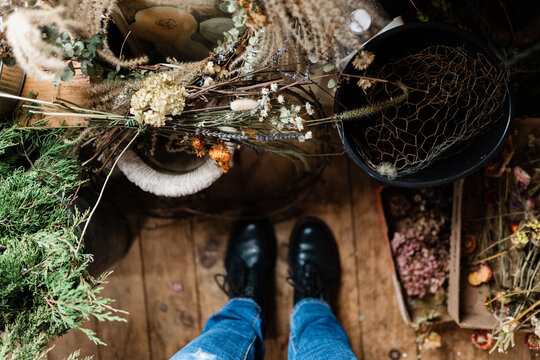 feet/ shoes with dried flowers on the floor