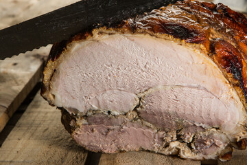 Mano con un coltello giallo taglia una fetta di roast-beef poggiato su un tavolo