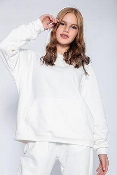 Beautiful blonde woman wear of white set of tracksuit isolated on gray background. Portrait of young woman wearing grey sportswear sweatshirt hoodie, isolated studio image on white background