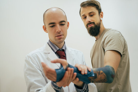 Doctor applying bandage on hand of patient