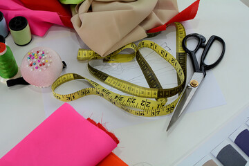 Fashion clothing design drawing and tools on designer desk.