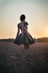 Girl in a dress standing in the field