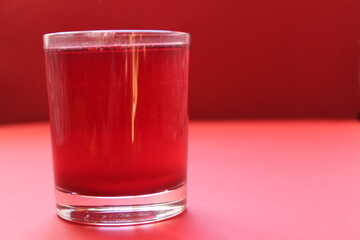 red drink of milky preparation of raspberry blueberries or kulbnik mors juice compote on a red background with a place for text and copyspace © Кристина Шоба