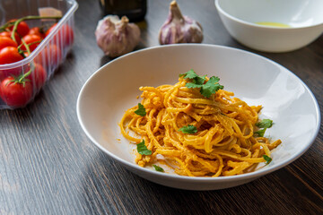 Creamy vegan linguine pasta in cherry tomatoes and cashew sauce. Tasty and fresh Italian dish with garlic, olive oil, and herbs. Authentic Italian cuisine with gluten free spaghetti ready to eat.