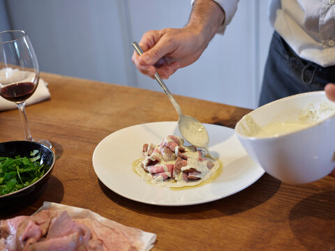 Chef pouring sauce on meat