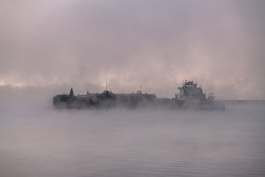 Empty cargo ships covered with fog in the shipyard