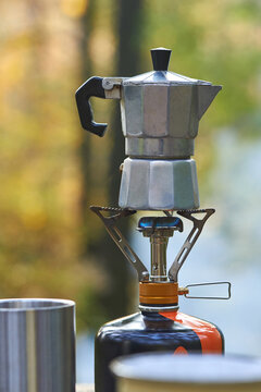 Metal coffee maker on a camping gas stove.