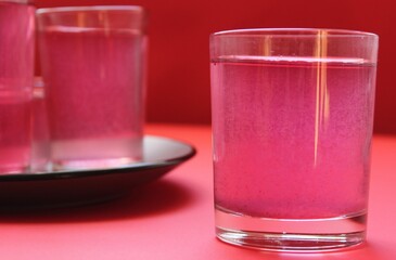 red drink of milky preparation of raspberry blueberries or kulbnik mors juice compote on a red background with a place for text and copyspace © Кристина Шоба